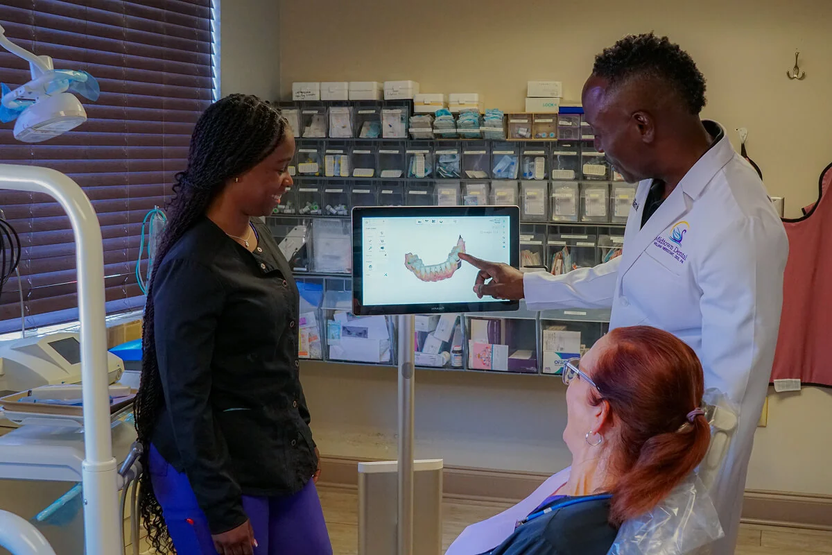 Dr. William Nerestant showing an emergency dentistry patient her dental scan