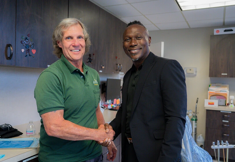 Dr. William Nerestant shaking hands with a new patient at Midtown Dental in Lakeland, FL